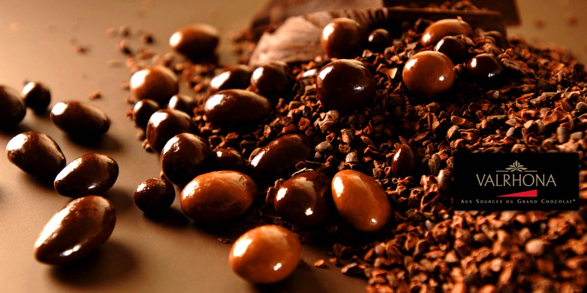 Bolas de Valrhona Equinoxe Mimese a usted y a sus seres queridos con almendras y avellanas crujientes cubiertas con el mejor chocolate negro Valrhona.